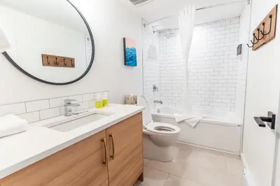 a bathroom with a sink and a toilet and a mirror at Basecamp Resorts Revelstoke in Revelstoke