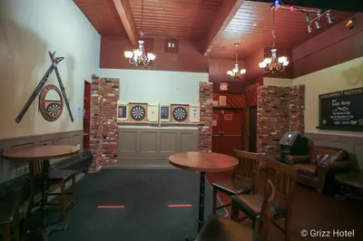 a bar with two tables and chairs in a room at Grizz Hotel in Revelstoke