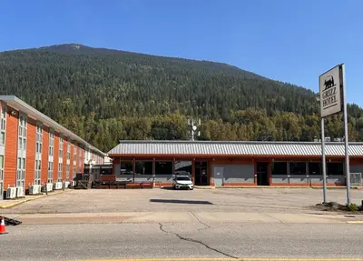 a car parked in a parking lot in front of a building at Grizz Hotel in Revelstoke