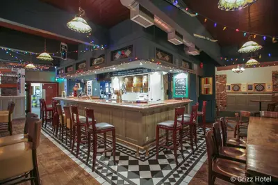 a bar in a restaurant with chairs and tables at Grizz Hotel in Revelstoke