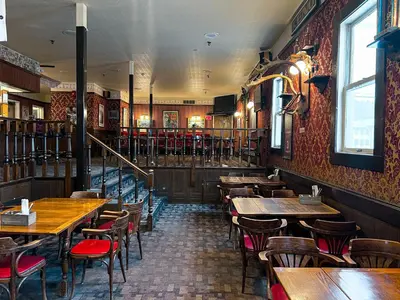 a restaurant with tables and chairs and a bar at The Downtown, a Coast Hotel in Dawson City