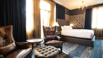 a hotel room with a bed and a chair at Midnight Sun, a Coast Hotel in Dawson City