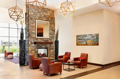 a living room with chairs and a fireplace at Four Points by Sheraton Kelowna Airport in Kelowna