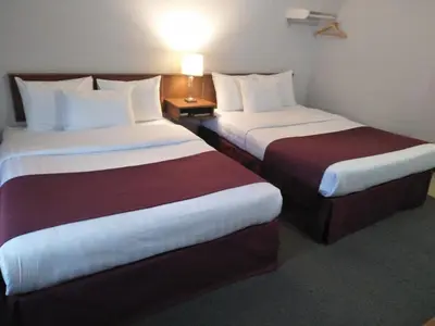 a hotel room with two beds and a lamp at Sundowner Motel in Cache Creek