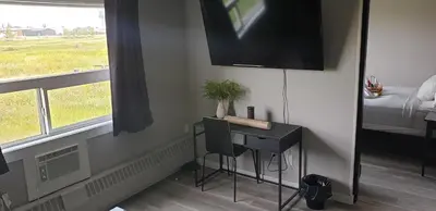 a room with a desk and a tv on the wall at New Frontier Hotel in Coronation