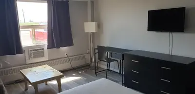 a bedroom with a desk and a dresser with a television at New Frontier Hotel in Coronation