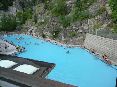 a group of people swimming in a blue pool at Modern Cozy 2 Bed 2 Bath with Lake and Mountain Views Pool and Hot Tub in Invermere