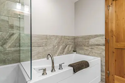 a bathroom with a sink and a bath tub at Spring Creek Luxury King One Bedroom at White Spruce Lodge in Canmore
