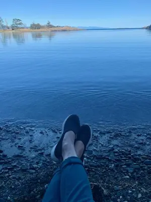 a person with their feet up on the edge of a body of water at A Cozy Family get away suite in South Nanaimo in Nanaimo