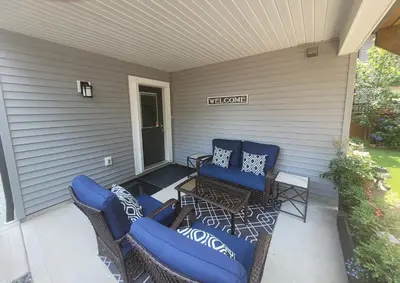 a patio with two blue chairs and a table at A Cozy Family get away suite in South Nanaimo in Nanaimo