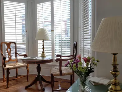 a living room with a table and chairs and windows at Vancouver Hideaway Guesthouse in Vancouver
