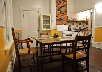 a kitchen with a table and chairs and a kitchen with a stove at Vancouver Hideaway Guesthouse in Vancouver