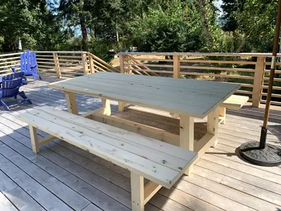 a wooden picnic table on a wooden deck at Forest by the Sea Rentals in Merville