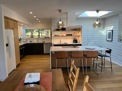 a kitchen with a table and some chairs and a counter at Forest by the Sea Rentals in Merville