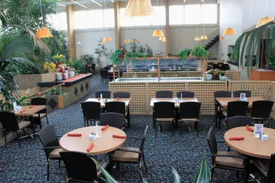 a restaurant with tables and chairs and a counter at Westlock Inn & Conference Centre in Westlock