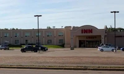 a store with cars parked in a parking lot at Westlock Inn & Conference Centre in Westlock
