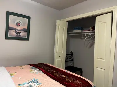 a bedroom with a bed and a picture on the wall at Hamptons Rose garden family! in Calgary