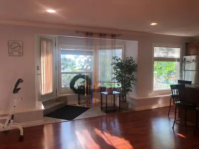 a living room with a table and two windows at Hamptons Rose garden family! in Calgary