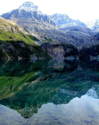 a reflection of a mountain in a lake at Mountain View Escape - Copperstone 2BR & Hot Tub in Canmore