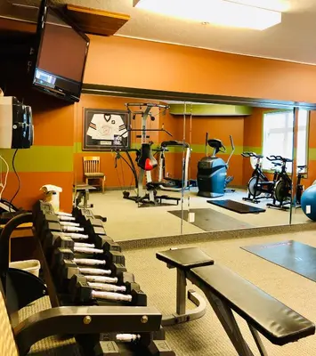 a gym with bikes and exercise equipment in a room at WindTower Resort - 1 Bed Hotel Room 166 in Canmore