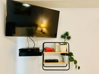 a flat screen tv hanging on a wall with a shelf at WindTower Resort - 1 Bed Hotel Room 166 in Canmore