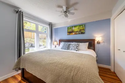 a bedroom with a bed with a ceiling fan and a window at Anniversary and Honeymoon 1 Bedroom Suite 168 in Canmore