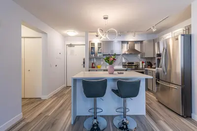 a kitchen with a blue island with two bar stools at Anniversary and Honeymoon 1 Bedroom Suite 168 in Canmore