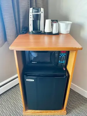 a wooden table with a coffee maker on top of aounter at Anavada Inn & Suites - Prince George in Prince George
