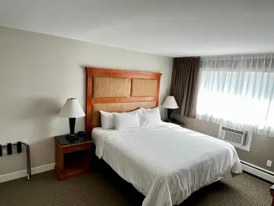 a hotel room with a large bed and a window at Anavada Inn & Suites - Prince George in Prince George