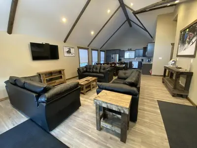 a living room with black leather furniture and a tv at Timber Lodge in Valemount