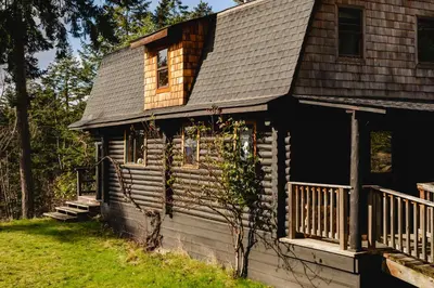 a log cabin with a porch and a deck at Bodega Ridge & Cove Cabins in Fernwood
