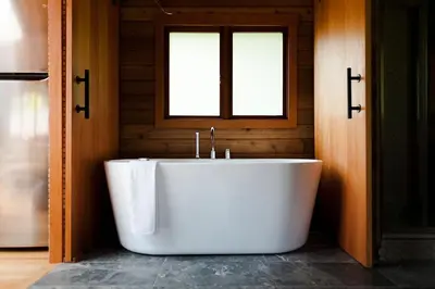 a bath tub in a bathroom with a window at Bodega Ridge & Cove Cabins in Fernwood