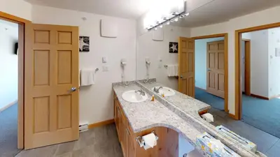 a bathroom with two sinks and a large mirror at Stoney Creek Northstar by Whistler Premier in Whistler