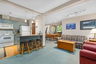 a living room and kitchen with a couch and a table at Stoney Creek Sunpath by Whistler Premier in Whistler