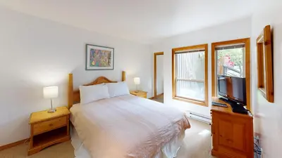 a bedroom with a bed and a flat screen tv at Painted Cliff by Whistler Premier in Whistler