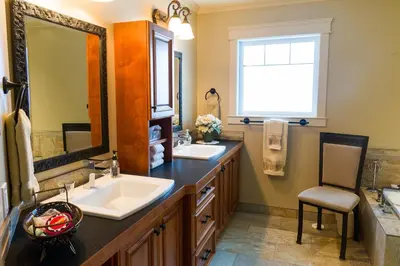 a bathroom with two sinks and a large mirror at Kootenay Wild Guest Suites in Nelson