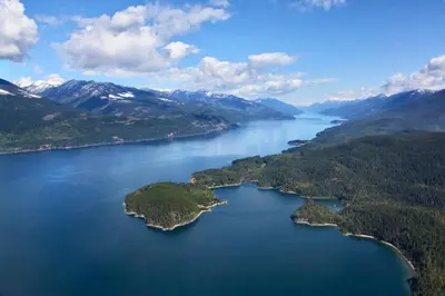 an aerial view of a lake in the mountains at Kootenay Wild Guest Suites in Nelson