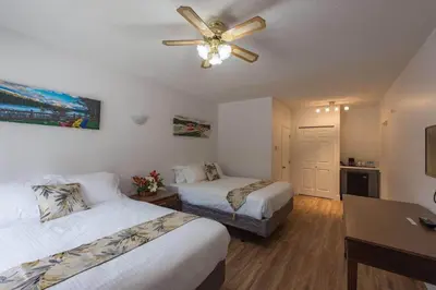a hotel room with two beds and a ceiling fan at David Thompson Resort in Cline River
