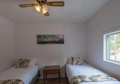 a room with two beds and a ceiling fan at David Thompson Resort in Cline River
