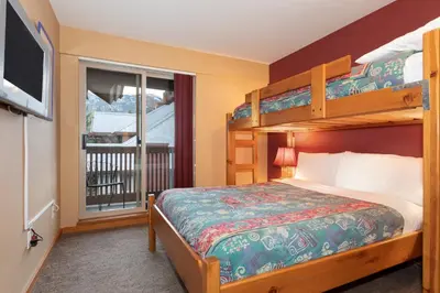 a bedroom with a bunk bed and a balcony at Symphony by Whistler Premier in Whistler