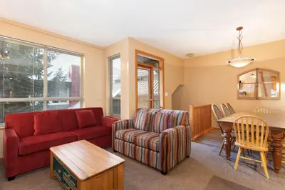 a living room with a red couch and a table at Symphony by Whistler Premier in Whistler