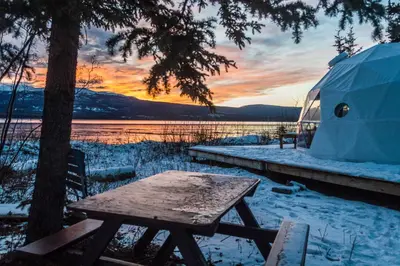 a picnic table in the snow next to a tent at Little Atlin Lodge in Tagish