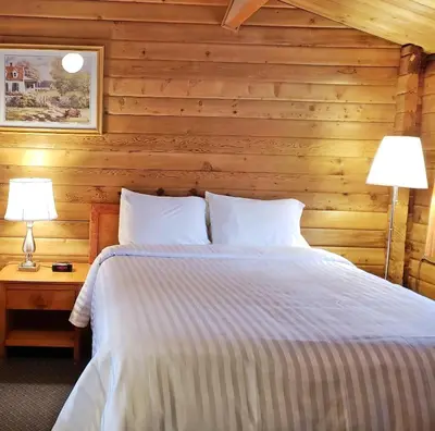 a bedroom with a bed and two lamps on a table at Rocky Inn in Valemount
