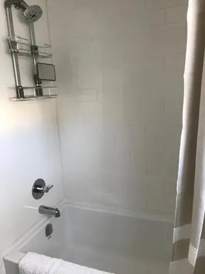 a bathroom with a bath tub with a shower at Your home away from home in Kelowna