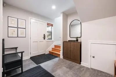 a hallway with a mirror and a staircase in a house at The Woods by Outpost Whistler in Whistler