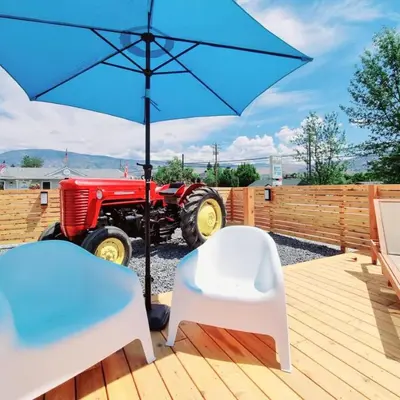 a blue umbrella and a tractor on a deck at The Orchard at Oliver in Oliver