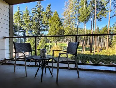 two chairs and a table on a porch with a window at Fairways Hotel on the Mountain in Victoria