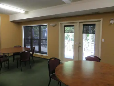 a conference room with two tables and chairs and windows at Village Creek Country Inn in Westerose