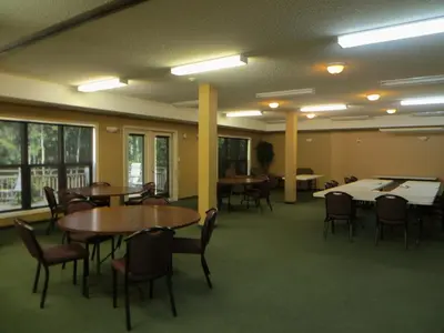 a large room with tables and chairs and tablesktop at Village Creek Country Inn in Westerose