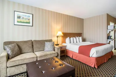 a hotel room with a bed and a couch at Quality Hotel in Drumheller